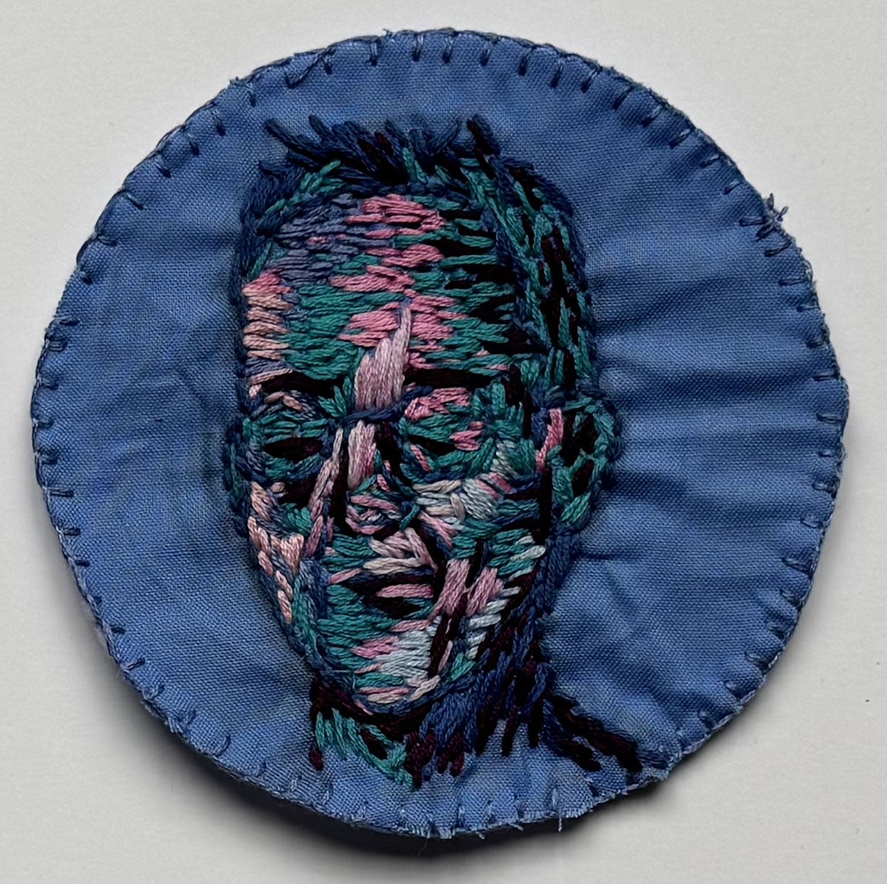 portrait of person rendered in different colored thread