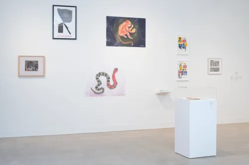 gallery shot with a wall full of artworks by different artists