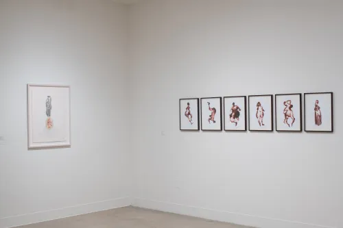 corner of gallery featuring work by two different artists on each side, one drawing, one watercolor
