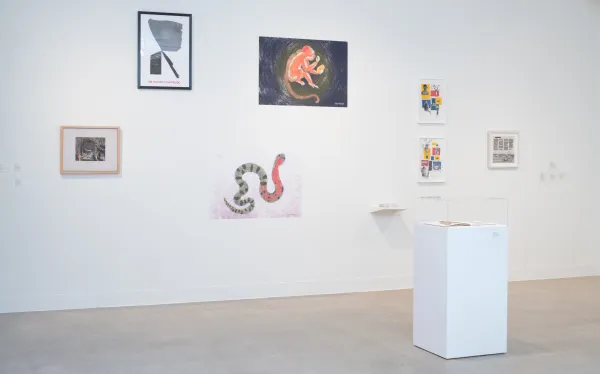 gallery shot with a wall full of artworks by different artists