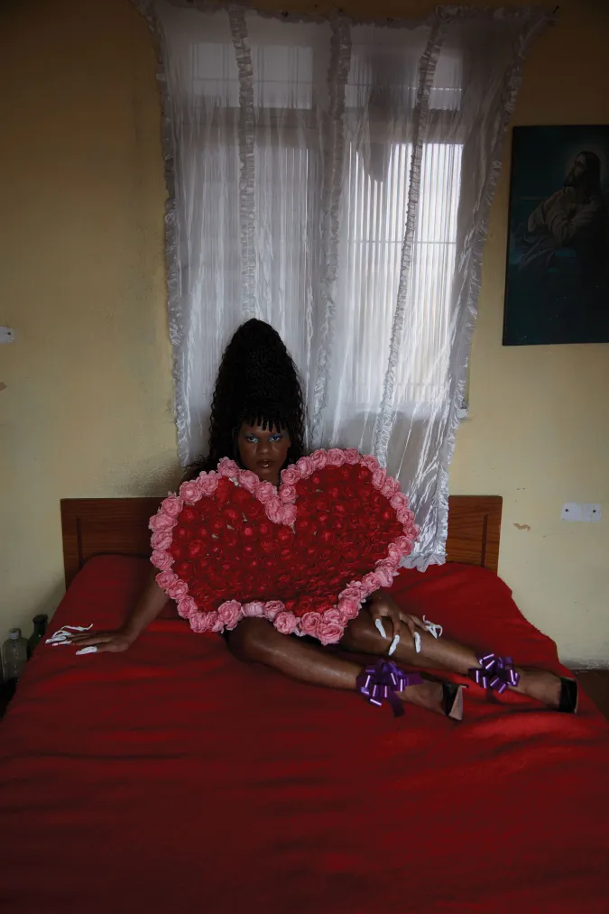 person laying on bed holding red and pink heart piece