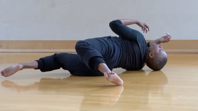 person laying on floor in twisted position