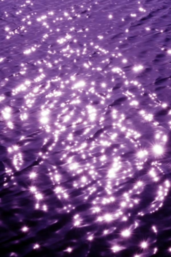 surface of water with ripples and cast in purple hue