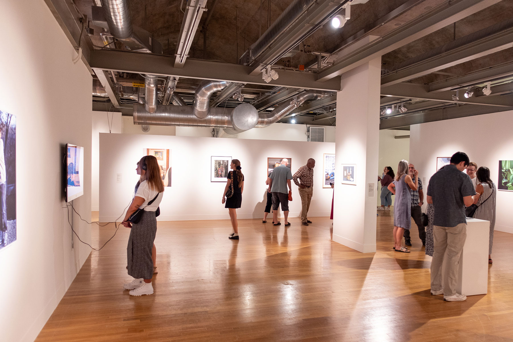 people looking at art in gallery during exhibition opening