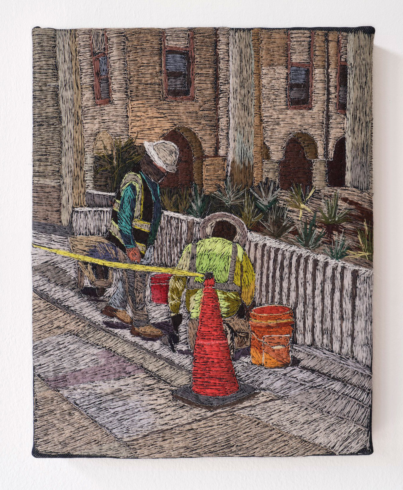 embroidered artwork that portrays utility workers at a manhole in street