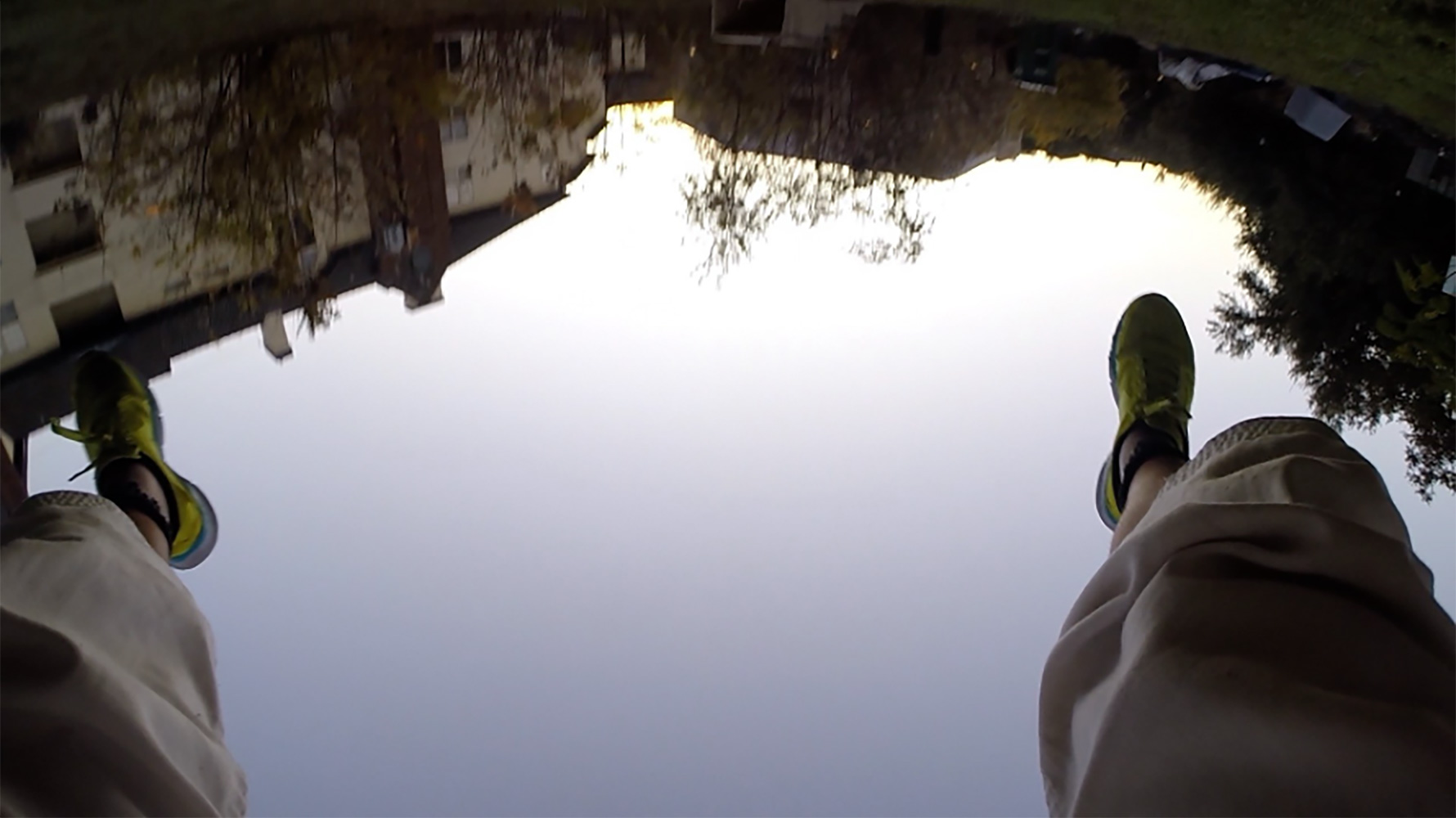 composite image of human legs and feet shown above reflection of water in landscape