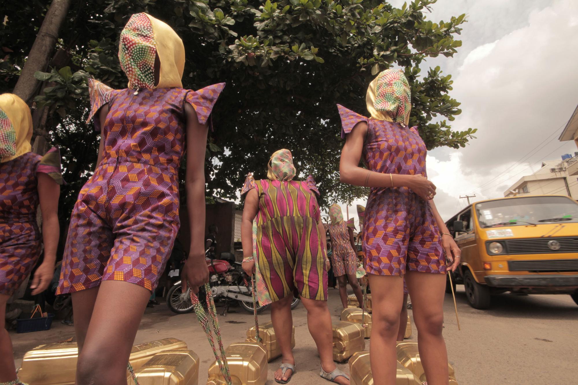 figures in costume walking in unison along street