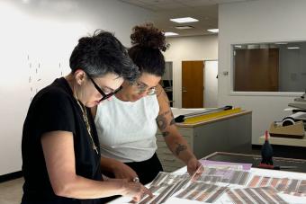 two people looking at film negatives on light table