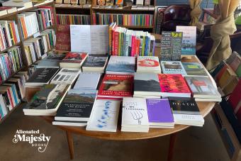 table covered in books at Alienated Majesty Books