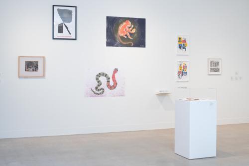 gallery shot with a wall full of artworks by different artists