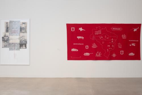 two textiles, left one framed, right one bright red with white painting on it