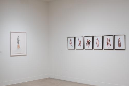 corner of gallery featuring work by two different artists on each side, one drawing, one watercolor