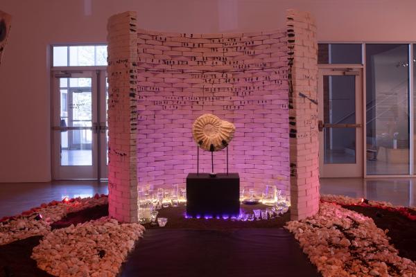 installation image of ammonite fossil surrounded by curved brick wall