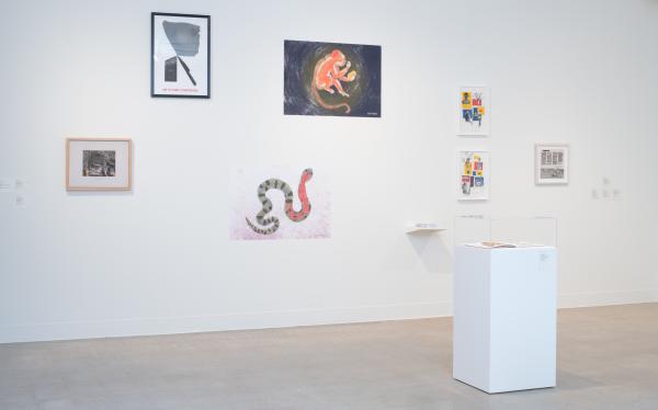 gallery shot with a wall full of artworks by different artists