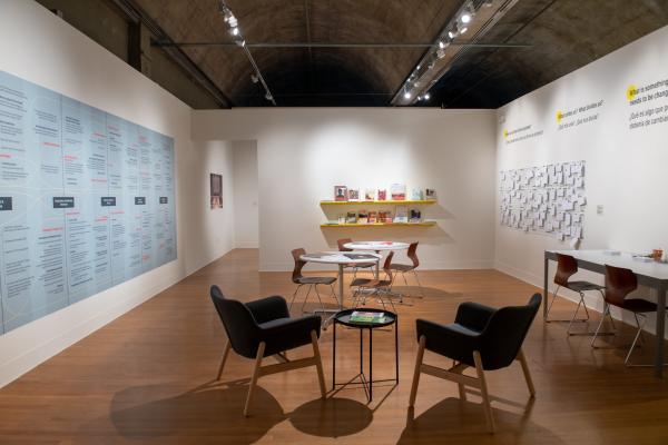 reading room featuring a table and chairs with a large sociogram pasted on the wall to the left and books to the right