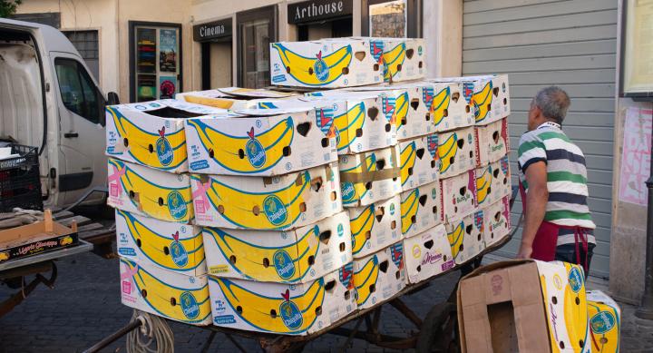 person stacking large box printed with yellow banana graphic