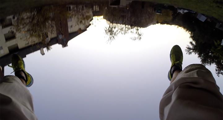 composite image of human legs and feet shown above reflection of water in landscape